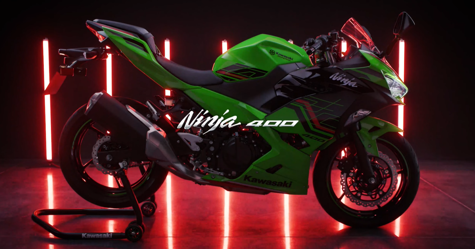 A Kawasaki Ninja 400 displayed with dramatic red lighting in a dark studio
